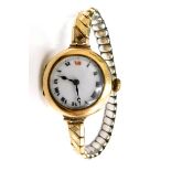 A late 19thC 9ct gold cased wristwatch, the white enamel dial with Roman numerals, in a 9ct gold cas