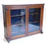 An early 19thC mahogany freestanding library bookcase, the top with a moulded crest above two glazed