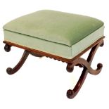 A Victorian mahogany stool, with a green upholstered padded seat, on scroll carved X shaped supports
