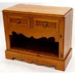 A pine side cabinet, the raised top with a plain edge above two panel drawers and a dog kennel reces