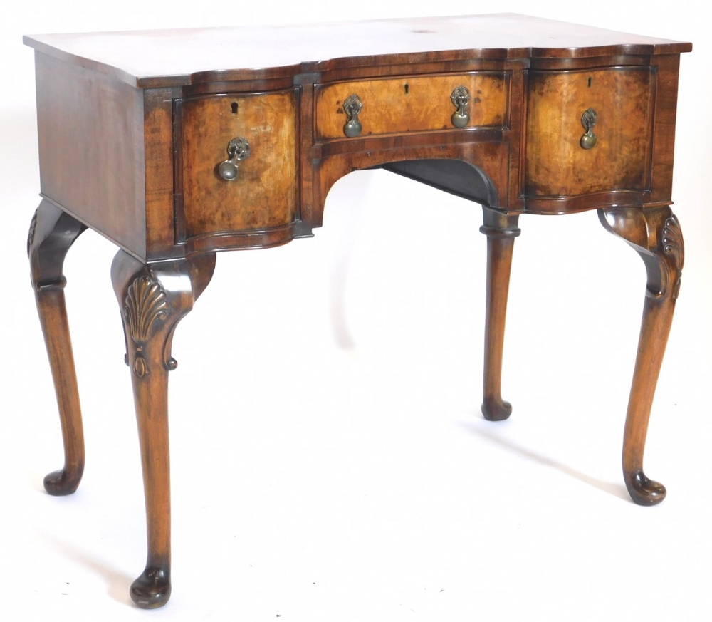 A burr walnut dressing table in mid 18thC style, the crossbanded inverted breakfront top above a fri