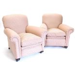 A pair of Edwardian armchairs, upholstered in pink geometric fabric, on bun feet.