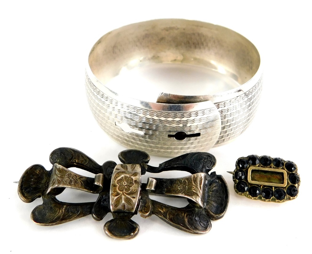 A group of jewellery, to include a silver bangle, with feather edged detailing, a silver faux brooch
