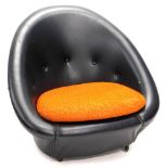 A 1960s retro black leatherette egg shaped chair, with yellow cushion, 86cm wide. The upholstery in