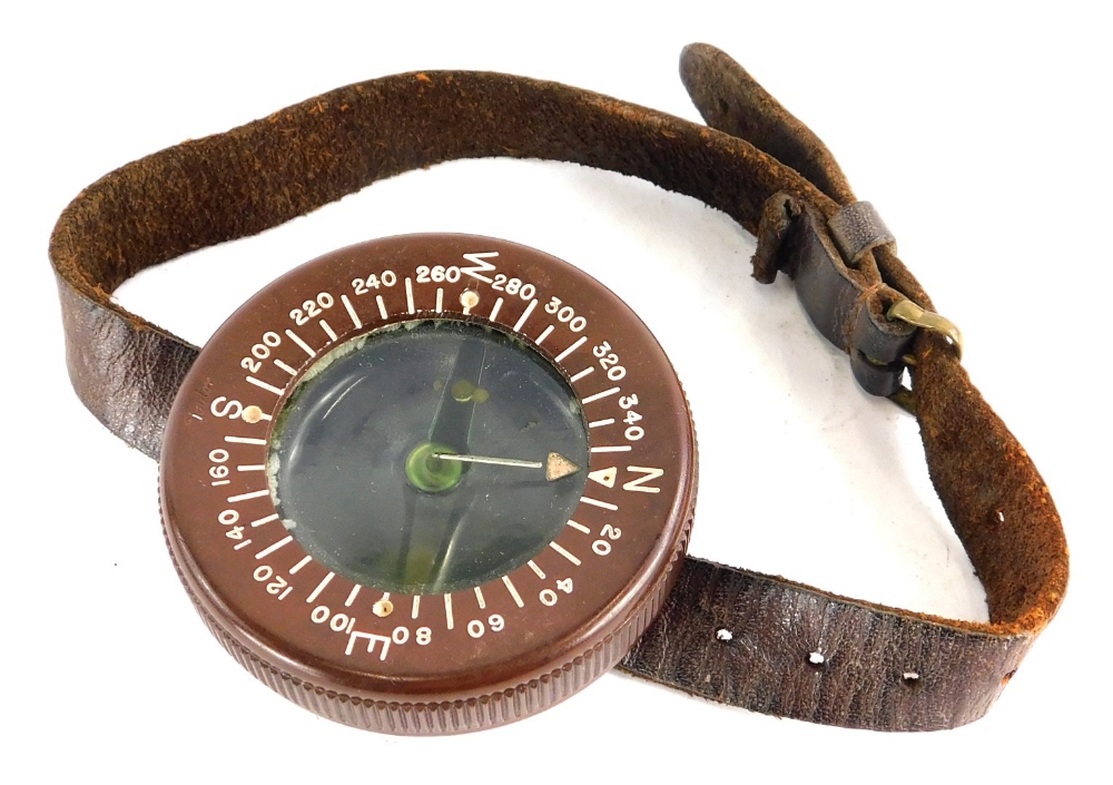 A WWII US Army Airborne wrist compass, in brown Bakelite with leather strap.