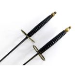 A pair of 19thC Solingen fencing foils, 86cm long, with leather handles and brass mounts, the blade