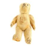 An early 20thC small teddy bear, with straw filling, one eye, (AF), 21cm long.