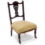 A late 19th/early 20thC walnut nursing chair, with a carved pierced splat, a padded seat on turned l