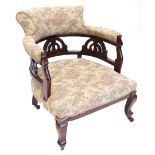 A late 19th/early 20thC walnut tub shaped chair, upholstered in floral fabric, on cabriole legs.