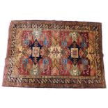 An Afghan Kazak style rug, with a multi coloured design of lozenges, geometric devices, etc., in sha