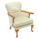A mahogany armchair, upholstered in green fabric, the shaped arms carved with eagles heads, on cabri
