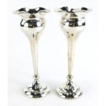 A pair of George VI silver trumpet shaped vases, with flared rims and a tapering stem, on a circular