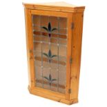 A pine hanging corner cabinet, the door inset with glazed leaded part stained glass and frosted pane