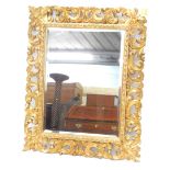 A late 18th/early 19thC giltwood wall mirror, the frame carved with scrolls, leaves, etc., surroundi