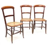 A set of three Victorian mahogany bedroom chairs, each with a caned seat on splayed legs.