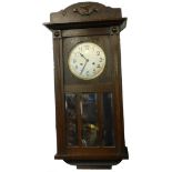 An oak cased mantel clock, with silvered dial, bevel glass, 76cm high.