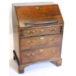 An 18thC oak bureau, the fall enclosing a fitted interior above three graduated drawers, each with b