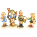 Four various Goebel Hummel design figurines, to include boy sitting on a branch, boy with basket, et