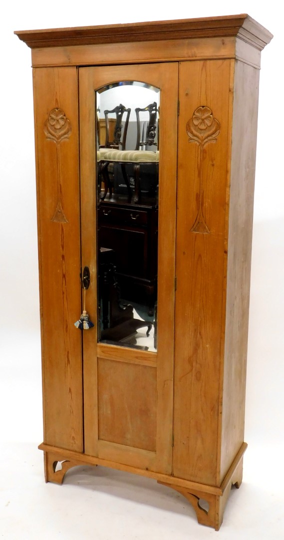 A late 19th/early 20thC pine Art Nouveau style wardrobe, with a moulded oak cornice, above a single