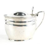 A Victorian silver mustard pot and cover, with shell cast thumb piece and blue glass liner, London 1