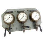 A set of three Budenberg brass pressure gauges, mounted onto metal, with a metal backing for Lub Oi