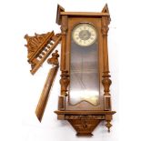 A late 19thC Vienna wall clock, in a walnut case, with carved shaped crest, the door with a glazed p