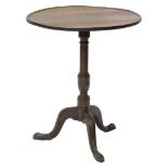 An early 19thC oak occasional table, the circular dished tilt top on a turned column and tripod base