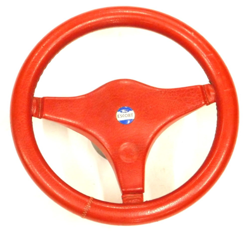 A red leather clad Ford Escort steering wheel, 33cm diameter.