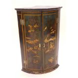 A late 18th/early 19thC Japanned bowfronted corner wall cabinet, decorated with oriental figures, bu