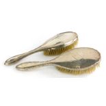 Two early 20thC silver backed hair brushes, one with a waved border and vacant cartouche, Birmingham