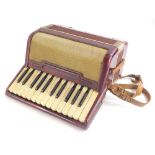 A small piano accordion, in red marbled case, possibly Italian, 32cm wide.