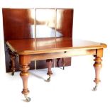 A large Victorian mahogany extending dining table, the rectangular top with a moulded edge and round