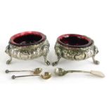 A pair of silver plated cauldron shaped salts, each with embossed decoration of flowers and scrolls,