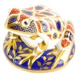 A Royal Crown Derby porcelain frog shaped paperweight, decorated in Imari colours, gold button.