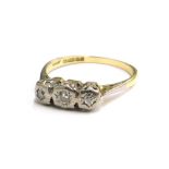 An 18ct gold three stone diamond ring, the three diamonds in rub over setting, in platinum setting,
