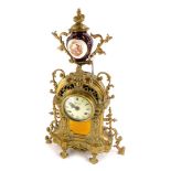 A Continental mantel clock, the rococo shaped cast brass case decorated with scrolls, the dial stamp