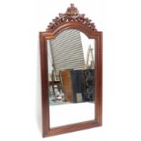 A mahogany wall mirror, with a leaf carved pierced crest, above a reeded arched frame, 147cm high, 7