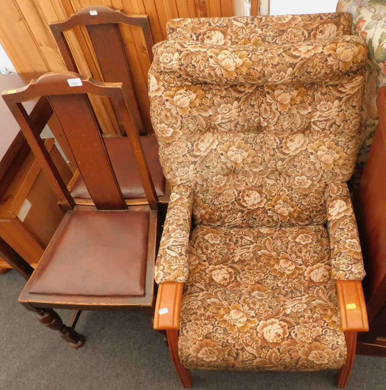 Two oak framed dining chairs, with drop in leatherette seats, and a floral patterned armchair. (3) T