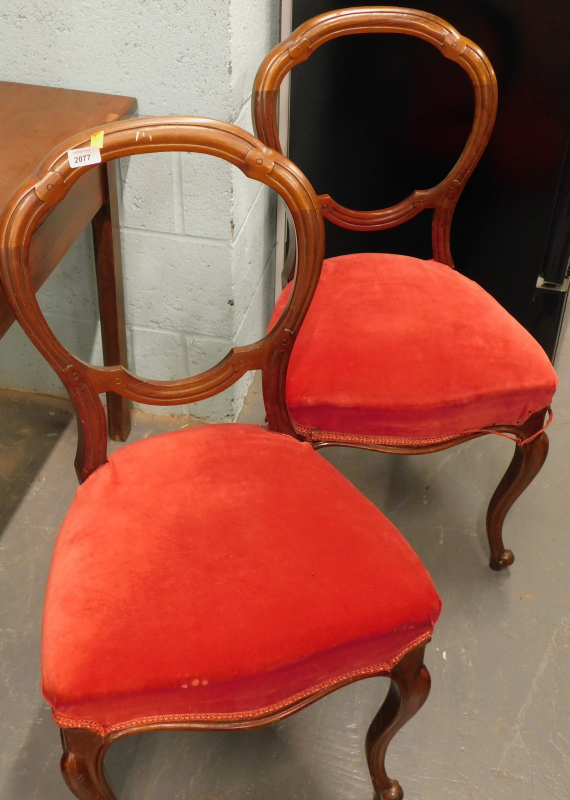 A pair of Victorian mahogany balloon back dining chairs, on cabriole legs, with overstuffed red velv
