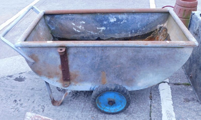 A galvanised metal corn barrow.