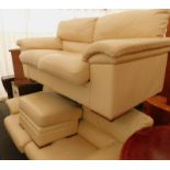 A pair of white leather two seater sofas, and an associated footstool.