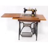 A Jones treadle sewing machine, in an oak and cast iron table base, with end supports, 93cm wide.