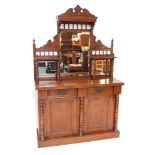 A Victorian walnut chiffonier, or side cabinet, the raised back with three bevelled mirrored plates,