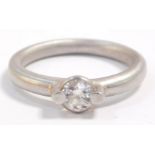 A platinum and diamond solitaire ring, in a pinned rub over setting, approximately 0.4cts, size L, 6