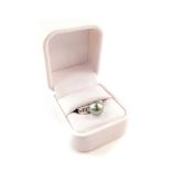 A 14ct white gold Tahitian cultured pearl and diamond ring, the high set pearl flanked by channel di