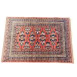 A Shiraz rug, red ground decorated with stylised field motifs and flowers, within repeating floral b