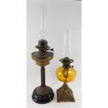 Two Victorian brass oil lamps, one with an amber glass reservoir, both with glass chimneys, 72cm hig
