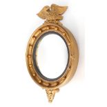 An Atsonea Regency style girandole wall mirror, with eagle mount, ebonised slip and convex glass, 60