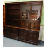 Two Ercol elm room units, each with a shaped and carved cornice, one section with shelves, two drawe