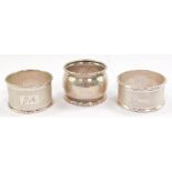 Two silver napkin rings, with engine turned decoration, and rectangular reserves, one monogram engra